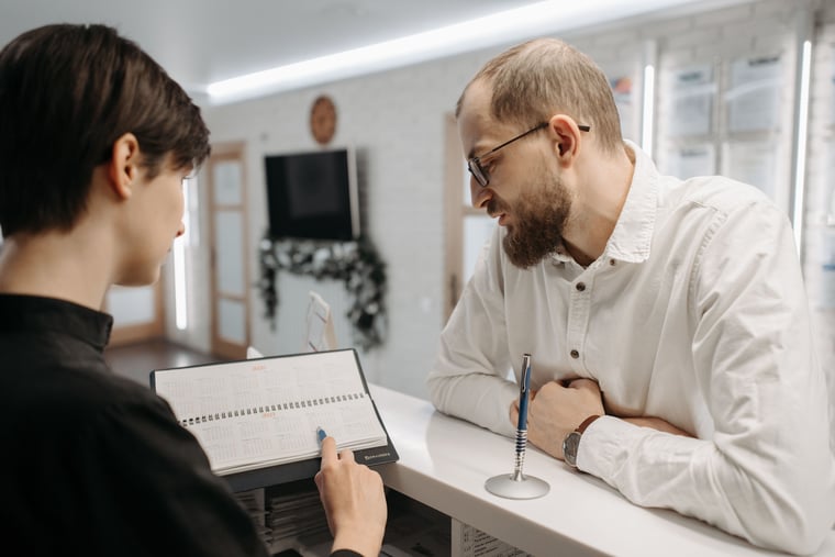 Practice staff member completing patient paperwork at the front desk